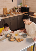 A papa and his kid are eating breakfast